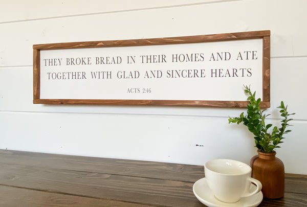 Farmhouse style wood sign with Acts 2:46 scripture painted on it.