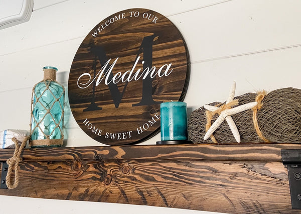 Farmhouse-style round wood sign with family name and initial