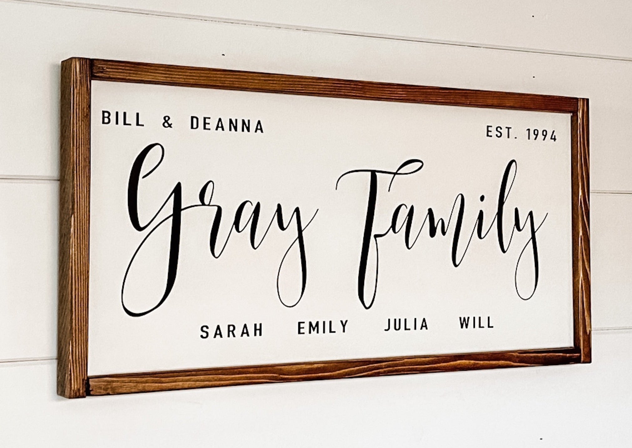 Handcrafted farmhouse style wood sign with the names of each family member and the established date