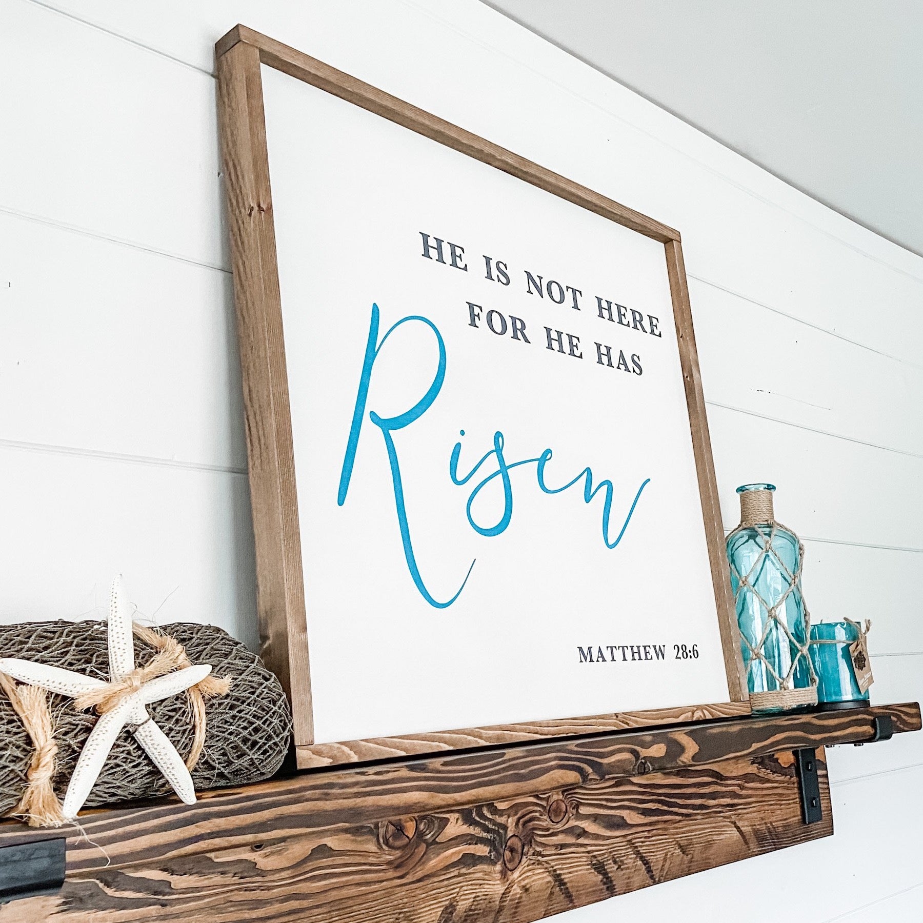 Farmhouse style wood sign with Matthew 28:6 scripture painted on it.